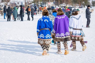 Russkinskaya, Rusya - 24 Mart 2018: Kuzeyde deri ve kürkten yapılmış ulusal kuzey kıyafetleri giyen hanlık erkekler, tatilin başladığı merkez cadde boyunca yürüyor. Reindeer çobanTatil.