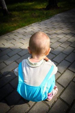 Takım elbiseli güzel çocuk Park'taki bir sokakta yürüyor.