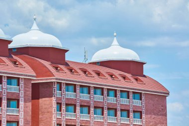 Mavi yaz gökyüzüne karşı beyaz kubbeli büyük kırmızı bina