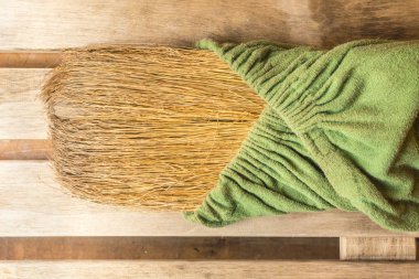 Banyoda yeşil havluya sarılı sarı süpürge.