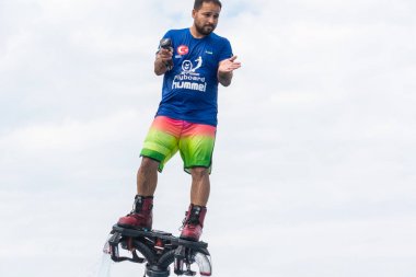 Side, Türkiye - 1 Haziran 2018: Yakışıklı tabaklanmış adam sineklikte duruyor ve bulutlarla mavi gökyüzüne uçuyor.