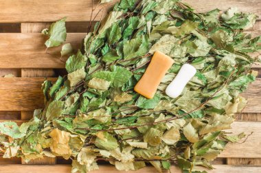 Banyodaki huş süpürgesinde iki sabun parçası yatıyor.