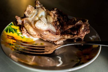 Bir çatal ile tabakta sığır eti haşlanmış et parçası.