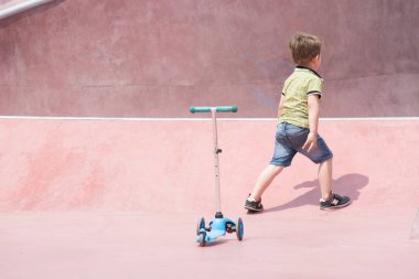 Krasnodar, Rusya - 7 Haziran 2018: Küçük çocuk özel spor sahasında çocuk scooter'ına biniyor.