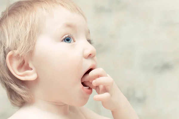 Голодна дитина з блакитними очима кладе їжу в рот . — стокове фото