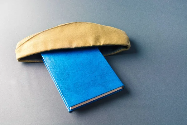 Yeşil askeri şapka mavi bir kitap giymiş — Stok fotoğraf