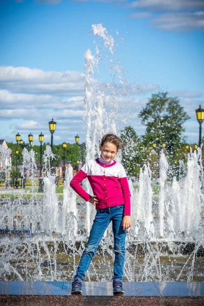 Enfant heureux posant à la fontaine dans le parc — Photo