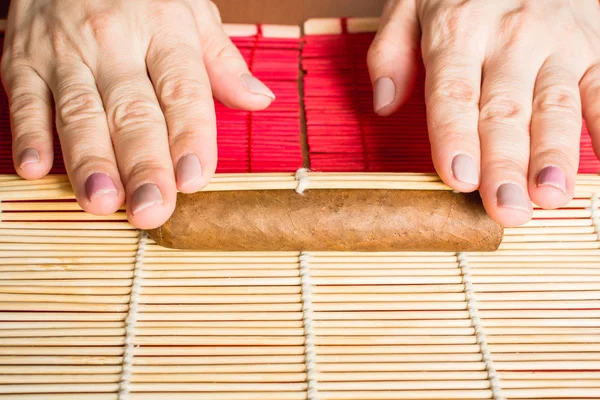 Hembra manos apretando cigarro casero con ayuda estera de bambú, concepto de cómo hacer cigarro —  Fotos de Stock