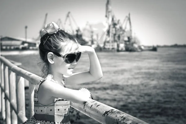 Belle enfant avec des lunettes ont un navire qui attend sur la jetée — Photo