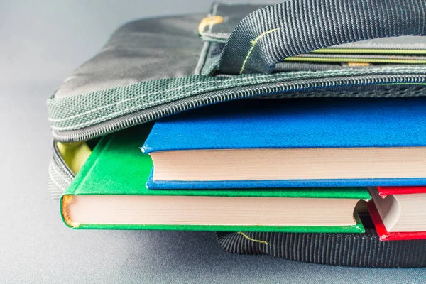 Куча разноцветных книг лежит в сумке для ноутбука — стоковое фото