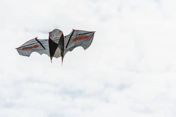 Beautiful bat shaped kite soars in the sky. Royalty Free Stock Images