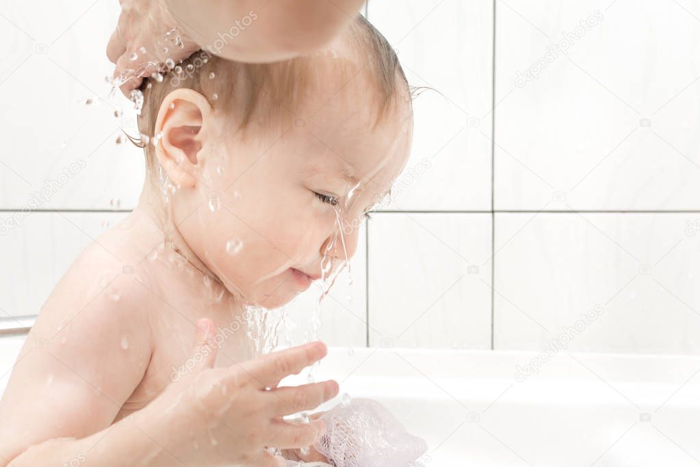 Happy baby girl bathing in bath