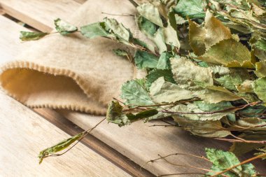 Huş süpürgesi banyoda beyaz bir şapka üzerinde yatıyor