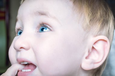Güzel çocuk ağzına parmaklarını ısırır