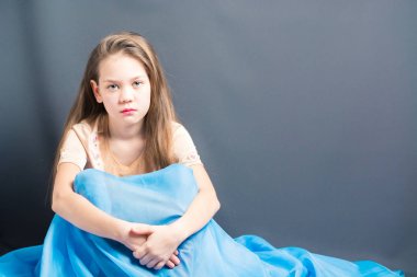 Mavi oryantal elbiseli güzel kız oturuyor