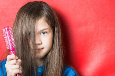 Elinde tarak tutan mavi bluzlu penye bir kız değil.