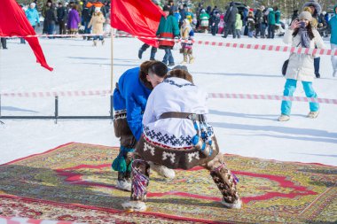 Russkinskaya, Rusya - 24 Mart 2018: Ulusal taiga giyimli iki sert adam, merkez meydanda halk için ellerinde güreşen erkeklerle uğraşıyor. Erkekler arasındaki mücadele için rekabet. Fea
