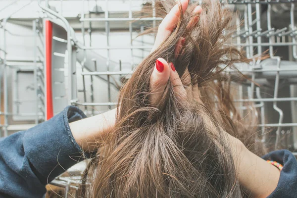 소녀는 식기 세척기 구획에 긴 기름기 머리를 낳는다 — 스톡 사진