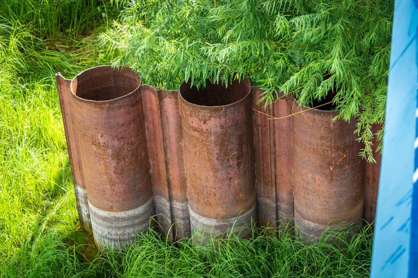 Trzy zardzewiałe rury pod drzewem — Zdjęcie stockowe