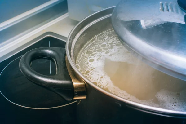 Железная сковорода на плите для супа — стоковое фото
