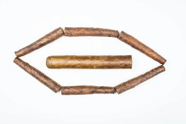 Big and small cigars twisted from sheets of tobacco on white background. — Stock Photo, Image