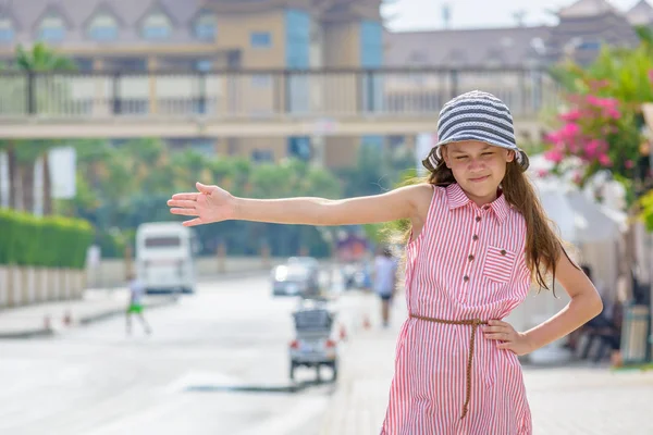 Lado, Turquía - Junio 2018: Muchacha sonriente en vestido de verano y sombrero con los ojos cerrados y la mano extendida para detener el coche con el fin de dar ascensor . —  Fotos de Stock