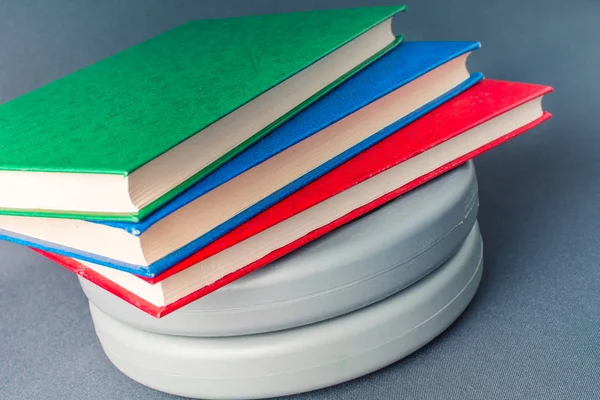 Livros multicoloridos estão em panquecas cinzentas de um bar de esportes — Fotografia de Stock