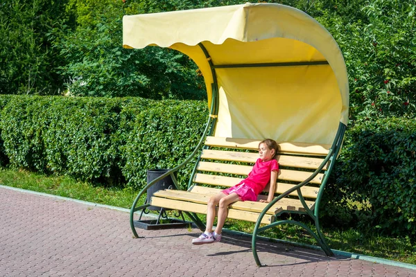 公園のベンチで休んでいる小さな女の子 — ストック写真