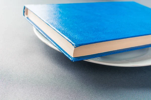 Красива блакитна книга лежить на білій тарілці — стокове фото