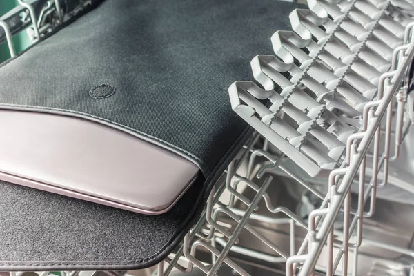 Laptop in a black case lies in the dishwasher — Stock Photo, Image