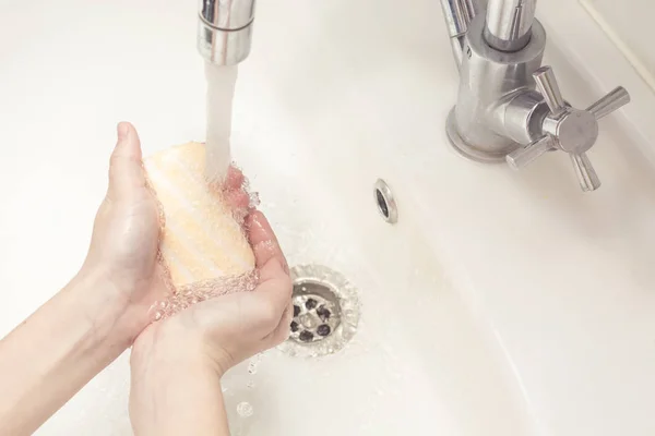 Child washing hands with soap and water.