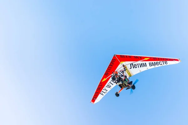 SIDE, TURKEY - JUNE 5, 2018: Beautiful hang glider in blue sky with people and inscription on wing fly together. — Stock Photo, Image