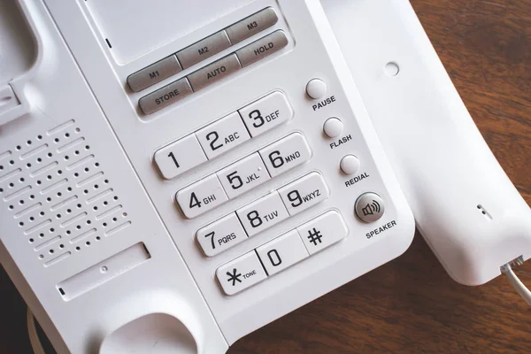 Telefone regular com botões na mesa de madeira . — Fotografia de Stock