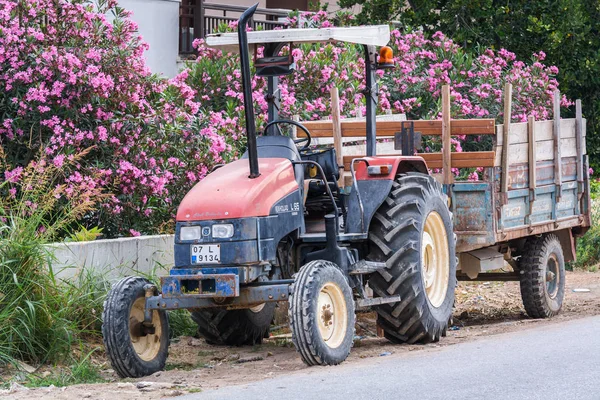 Strana, Turecko-4. června 2018: starý rezavý traktor na pozadí květin. — Stock fotografie