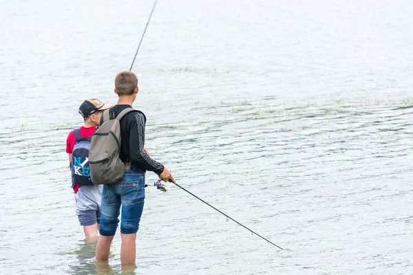 KRASNODAR, RUSSIE - 7 JUIN 2018 : Jeunes garçons en short pêchant avec des cannes à pêche dans le lac . — Photo