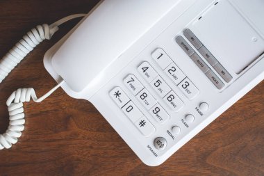 Tahta masadaki görüşmeler için beyaz telefon..