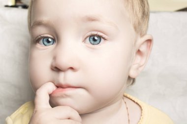 Güzel çocuk ağzına parmaklarını ısırır