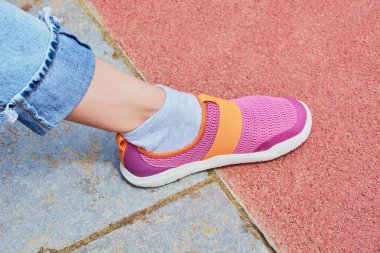 Spor ayakkabılı kadın bacağı tenis kortunda.