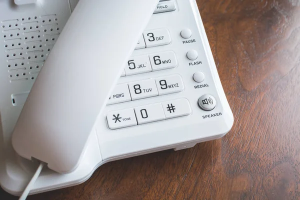 Λευκό τηλέφωνο στα κουμπιά με γάντζο στο ξύλινο τραπέζι. — Φωτογραφία Αρχείου