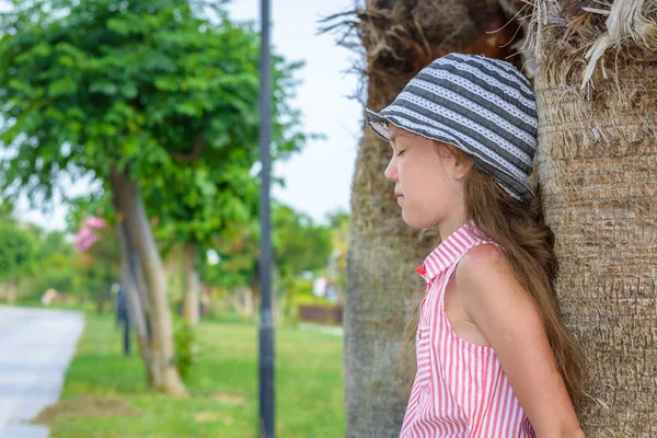 夏の帽子とストライプのドレスで美しい女の子はヤシの木で盲目的に費用がかかります. — ストック写真