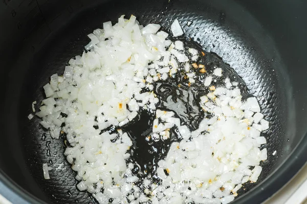 In Scheiben geschnittene Zwiebel gebraten in Multi-Herd-Schüssel zum Kochen. — Stockfoto