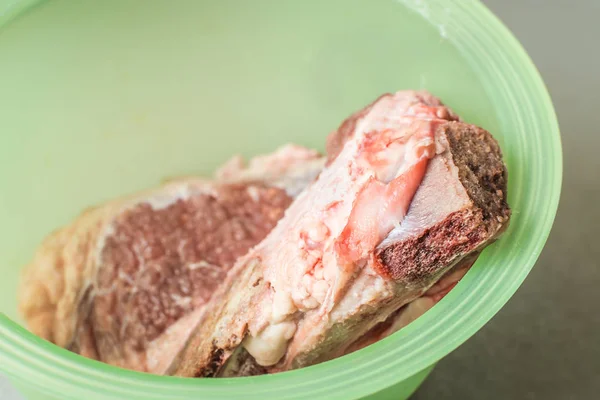 La carne cruda de ternera se descongela en un plato de cocción verde . — Foto de Stock