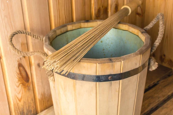 Бамбукова мітла на дерев'яному відрі в лазні — стокове фото