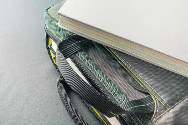 Gray book lies on a laptop bag — Stock Photo, Image