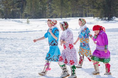 Russkinskaya, Rusya - 24 Mart 2018: Ulusal kuzey giyimli güzel kadınlar, kızlar arasındaki yarıştan sonra geri dönüyor. Reindeer çobanları günü bayramı.