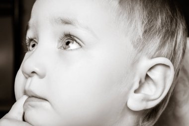 Güzel çocuk ağzına parmaklarını ısırır