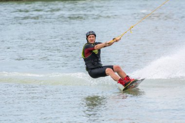 Krasnodar, Rusya - 7 Haziran 2018: Kasklı atletik adam su tutma ipinin üzerine biniyor.