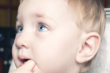 Güzel çocuk ağzına parmaklarını ısırır