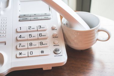 Ahşap masa üzerinde daire ofis telefonundan Tüp.