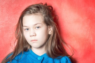 Kırmızı arka planda mavi kazak üzgün kız